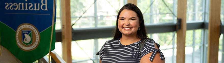 A UWF student smiles on a balcony in Building 76A.